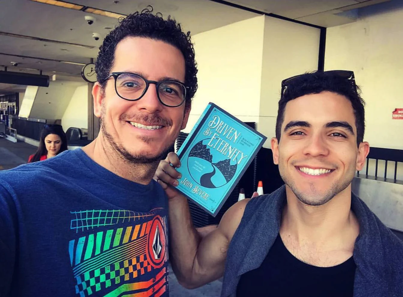Raphael and a friend smiling in a selfie holding a book