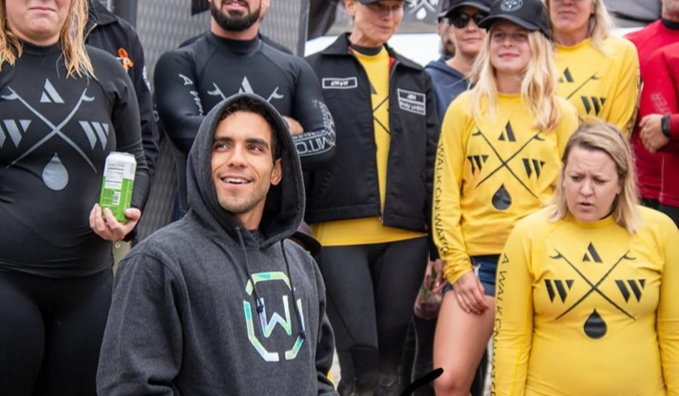 Raphael in a gray hoodie with a group of people in matching yellow and black shirts