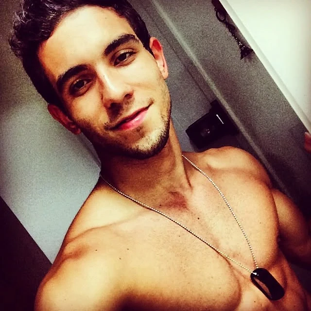 Raphael selfie, shirtless wearing a dog tag necklace